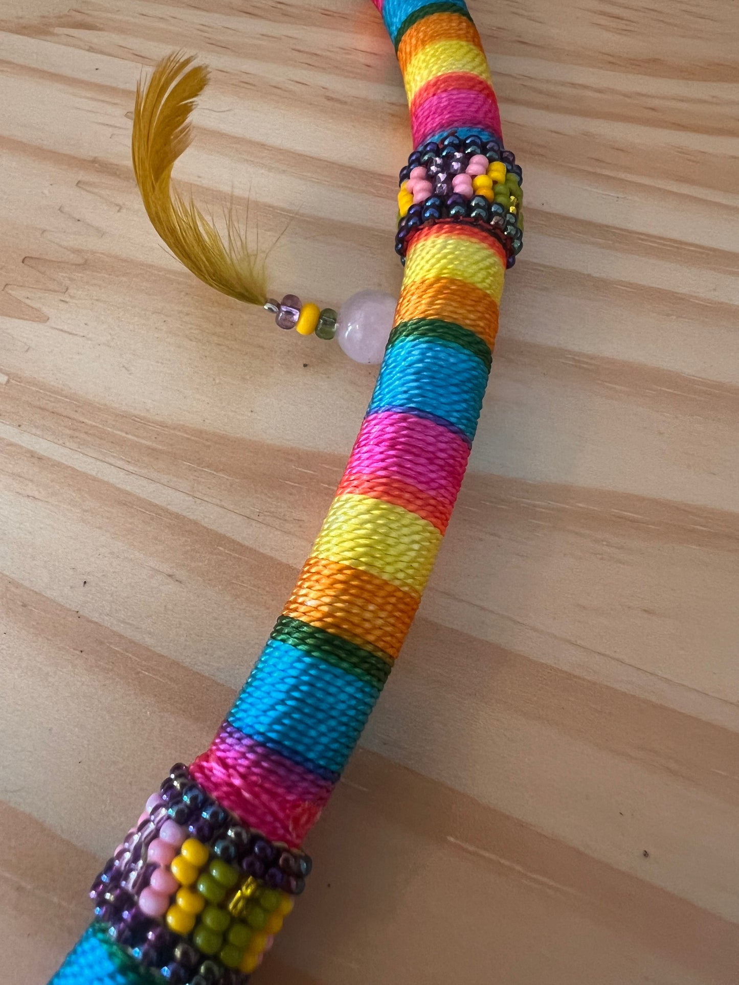 Rainbow-coloured bendable Tepi with feather