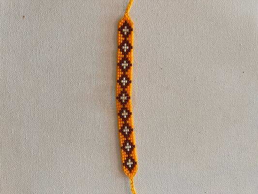 Yellow bracelet with white-brown patterns 2 cm x 13 cm