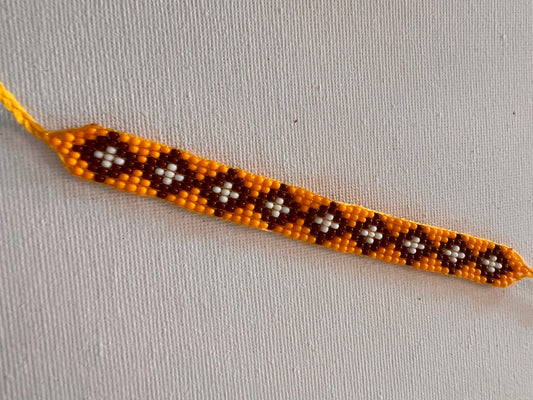 Yellow bracelet with white-brown patterns 2 cm x 13 cm