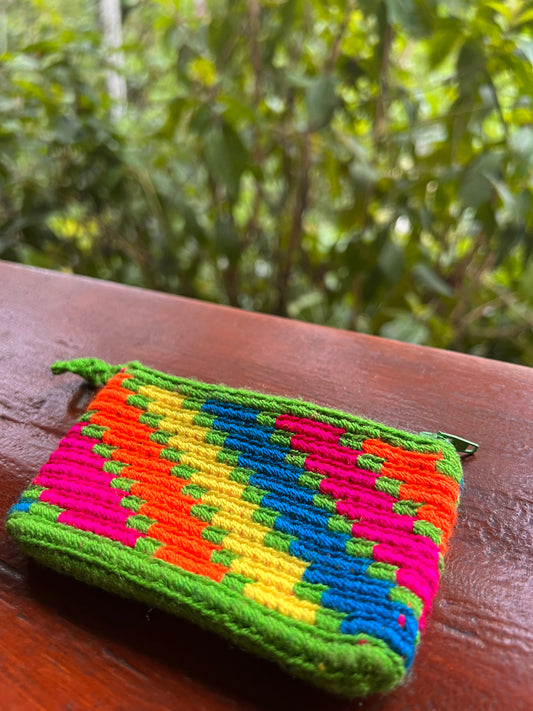 Light green Wayúu mini purse with rainbow colored patterns